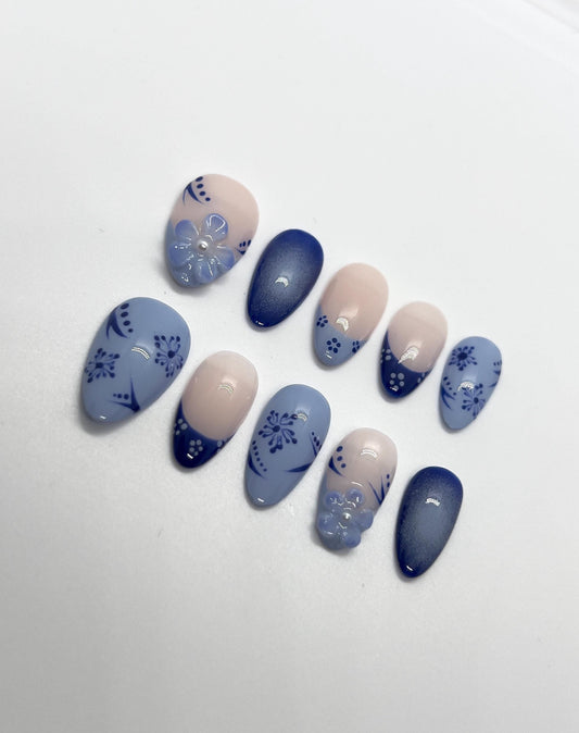 Handmade blue and beige press-on nails with Blue Floral Bloom design on a white background