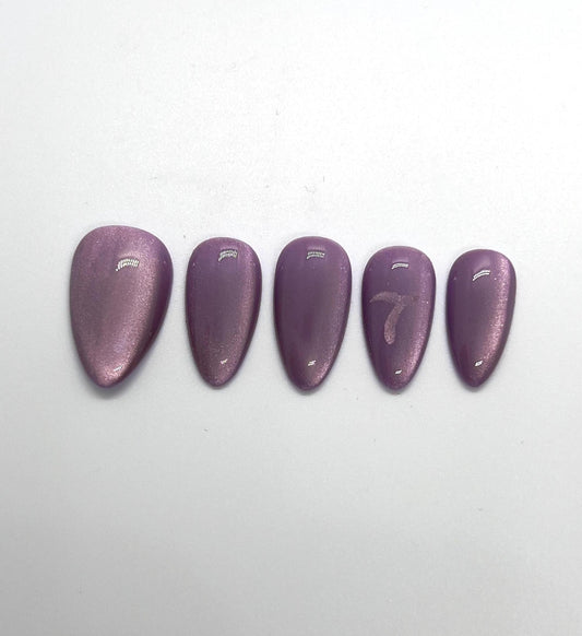 Handmade purple glittery press-on nails with 7 Purple Cat Eye design on a white background