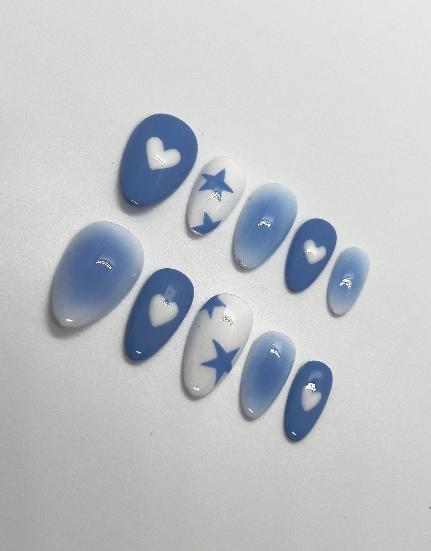 Step into a dreamy, futuristic glow with the Blue Lunar Chrome handmade press-on nail set, featuring soft lunar-blue gradients and reflective silver chrome details. This stunning design showcases abstract molten chrome patterns and delicate star accents that shimmer like moonlight, perfect for anyone who loves bold, celestial-inspired nails with a modern edge.