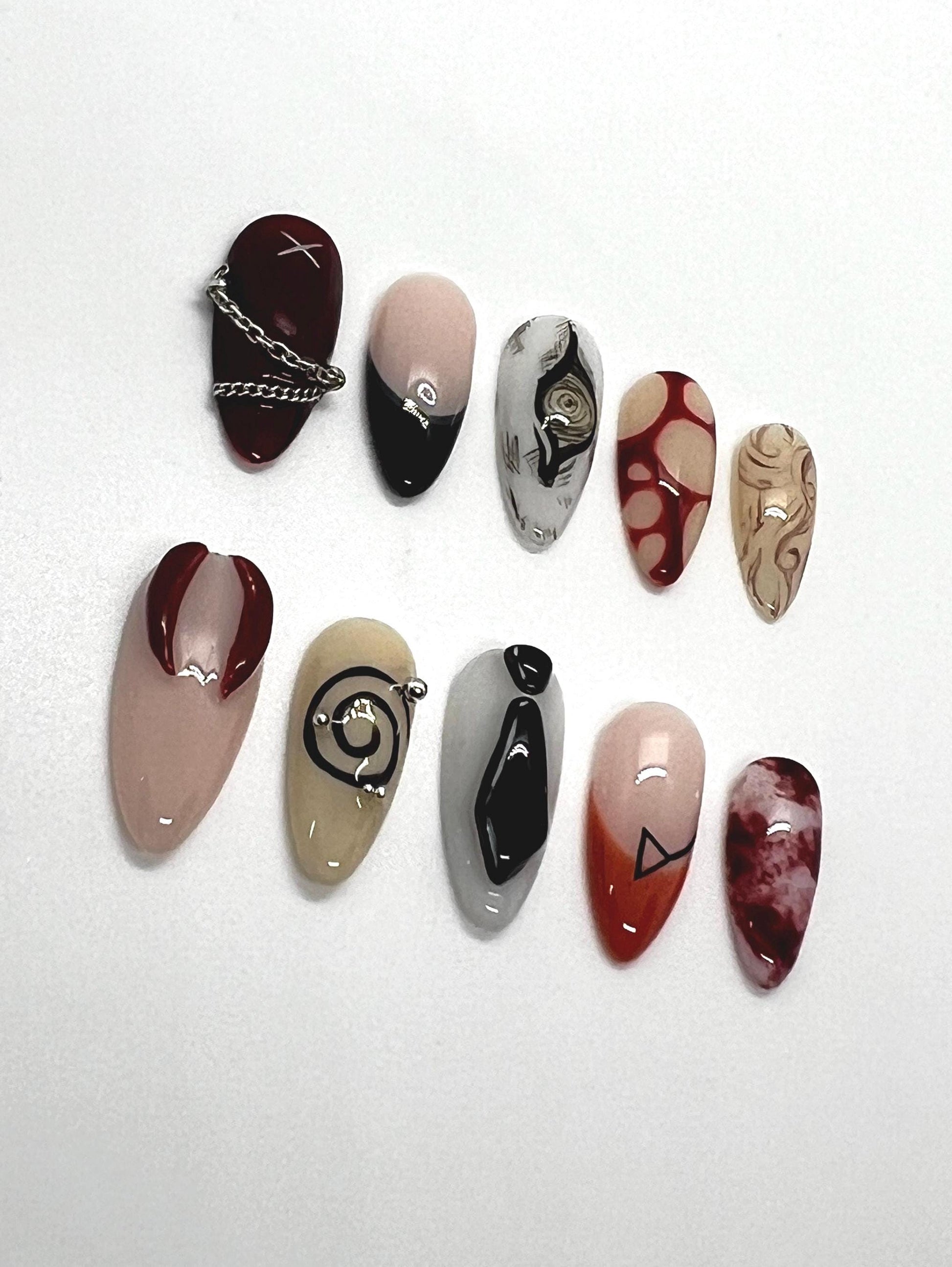 Handmade artistic press-on nails featuring Devil Contract and Chainsaw Man-themed designs on a white background