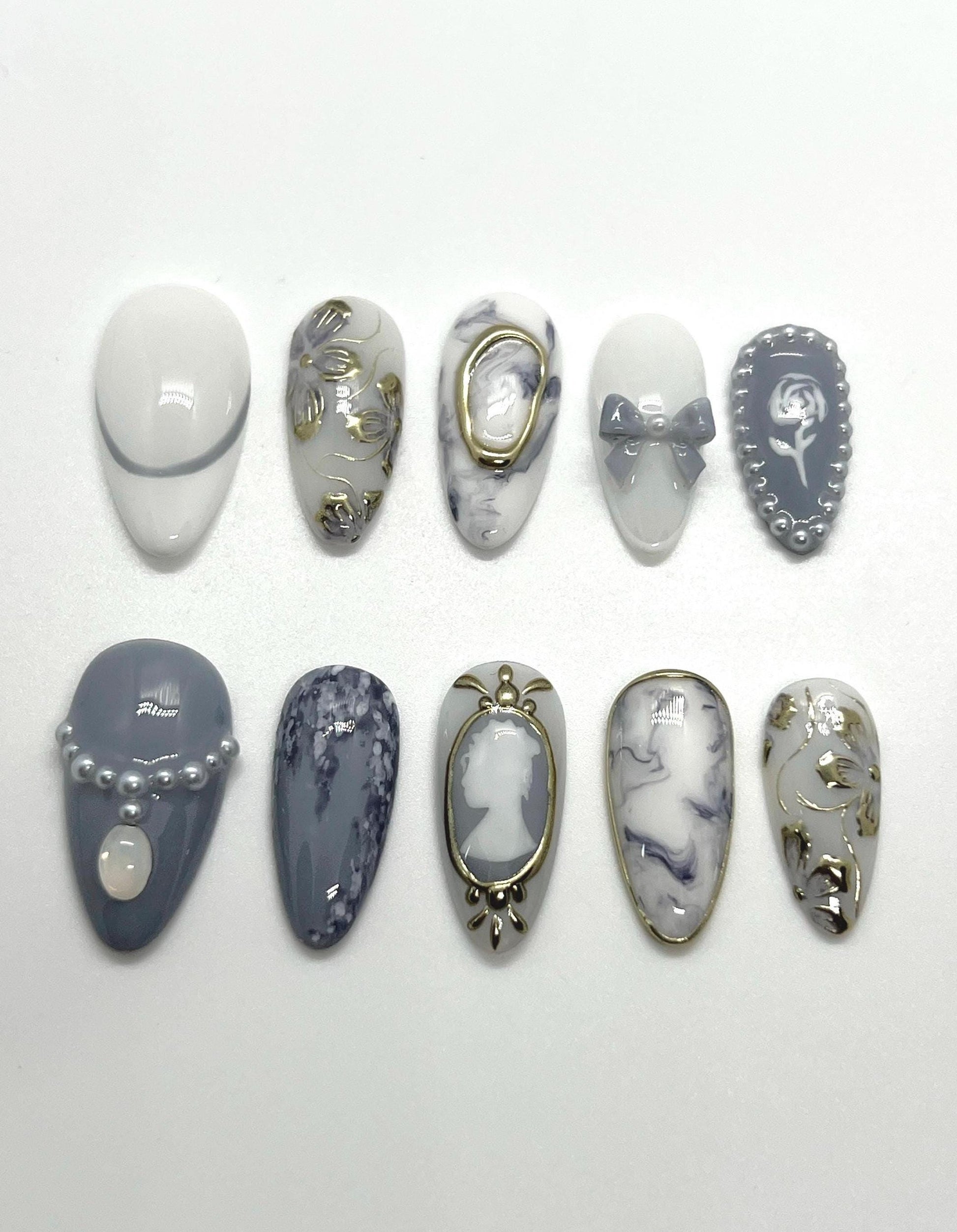This Bridgerton-inspired handmade press-on nail set captures the elegance and charm of Regency-era balls and whispered society secrets. Featuring soft pastels, pearl-like accents, and delicate gold detailing, these nails offer a refined yet romantic look—perfect for tea parties, formal events, or anyone ready to feel like the season’s most admired diamond.