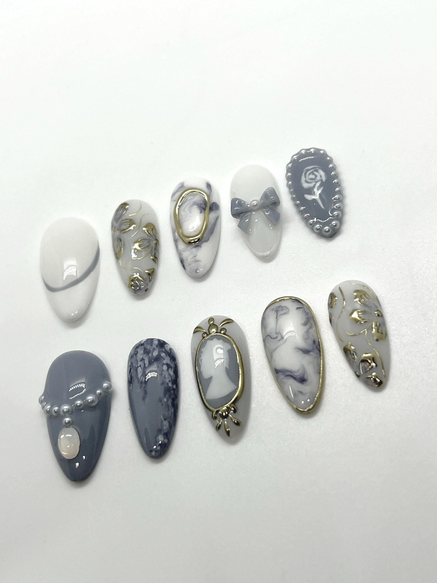 This Bridgerton-inspired handmade press-on nail set captures the elegance and charm of Regency-era balls and whispered society secrets. Featuring soft pastels, pearl-like accents, and delicate gold detailing, these nails offer a refined yet romantic look—perfect for tea parties, formal events, or anyone ready to feel like the season’s most admired diamond.