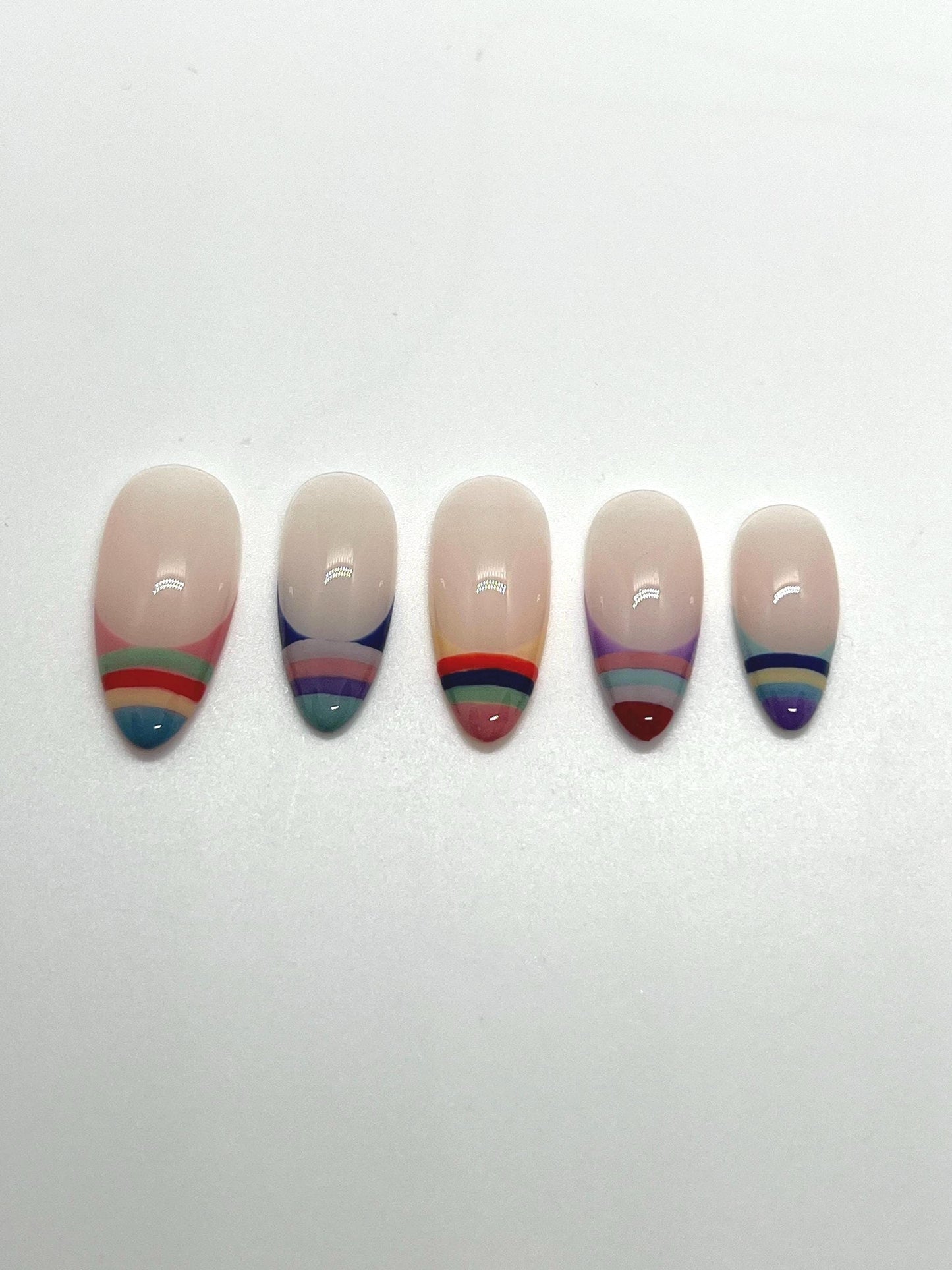 Handmade press-on nails with multicolored striped designs on a white background