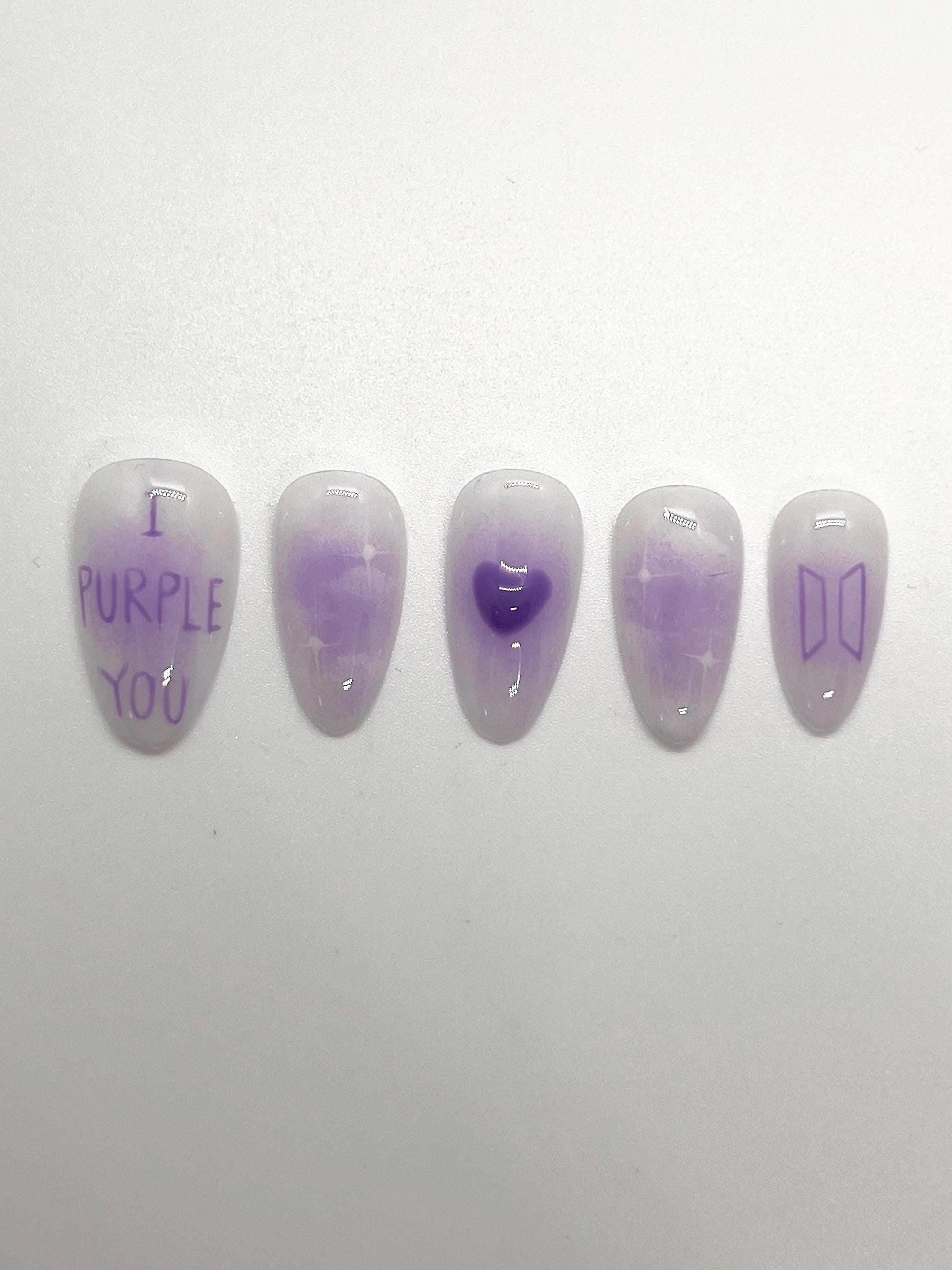 This BTS-inspired handmade press-on nail set features purple and white gradient tones with elegant detailing, inspired by BTS’s signature purple. Designed to represent love, trust, and the lasting bond between artist and fans, these nails are perfect for ARMYs who want a subtle yet meaningful look.