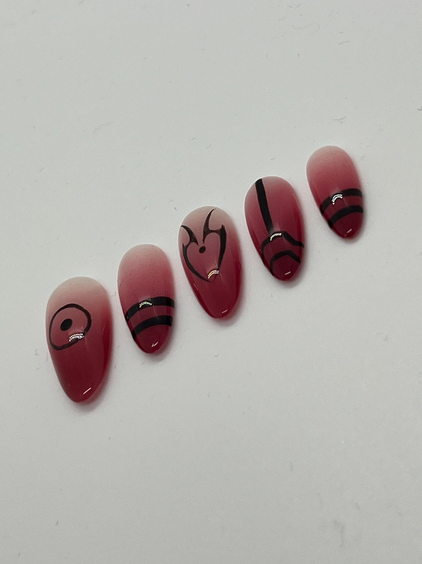 This Ryomen Sukuna-inspired handmade press-on nail set draws inspiration from the powerful and sinister energy of Jujutsu Kaisen. Featuring a red ombré base with bold black accents and intricate curse mark–style designs, each set perfectly captures Sukuna’s dark and regal aesthetic.

Each set includes five unique nail designs that mirror Sukuna’s distinct markings, making it ideal for anime fans, cosplay, or anyone looking to add a bold, mysterious edge to their look.