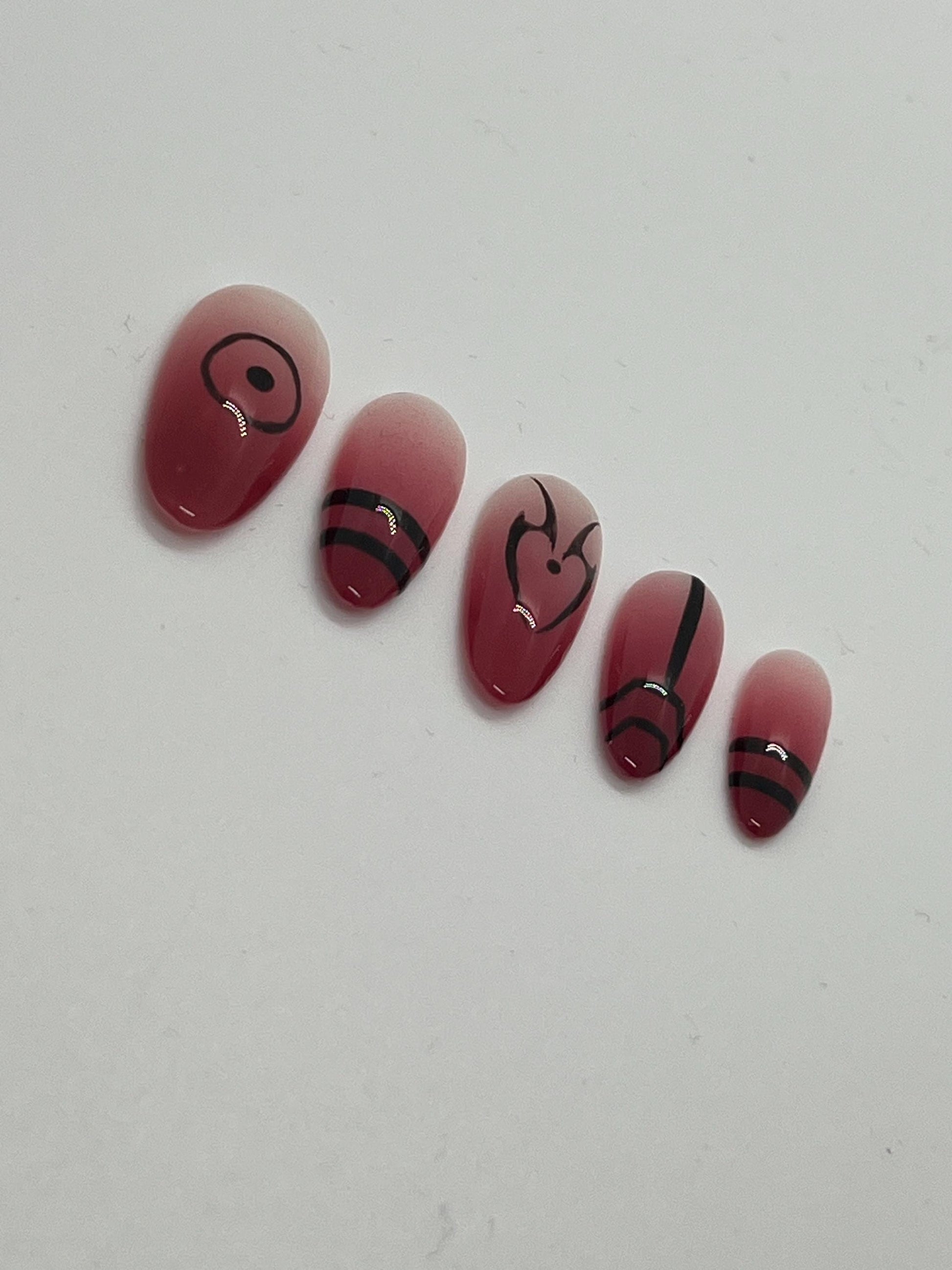 This Ryomen Sukuna-inspired handmade press-on nail set draws inspiration from the powerful and sinister energy of Jujutsu Kaisen. Featuring a red ombré base with bold black accents and intricate curse mark–style designs, each set perfectly captures Sukuna’s dark and regal aesthetic.

Each set includes five unique nail designs that mirror Sukuna’s distinct markings, making it ideal for anime fans, cosplay, or anyone looking to add a bold, mysterious edge to their look.