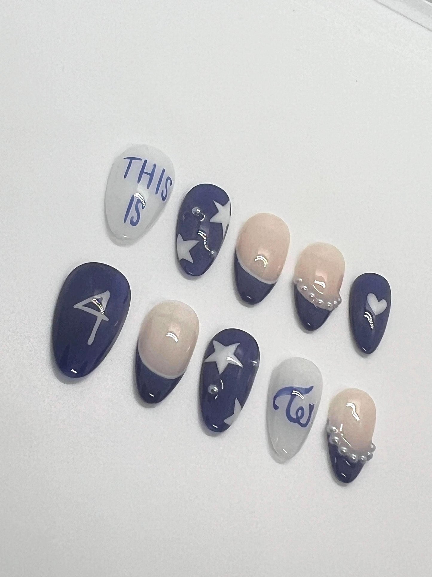 This TWICE-inspired handmade press-on nail set blends soft glam with playful charm, reflecting the group’s signature elegance and confidence. Featuring blue and beige tones with delicate details and polished finishes, these nails capture the essence of TWICE’s iconic stage presence.