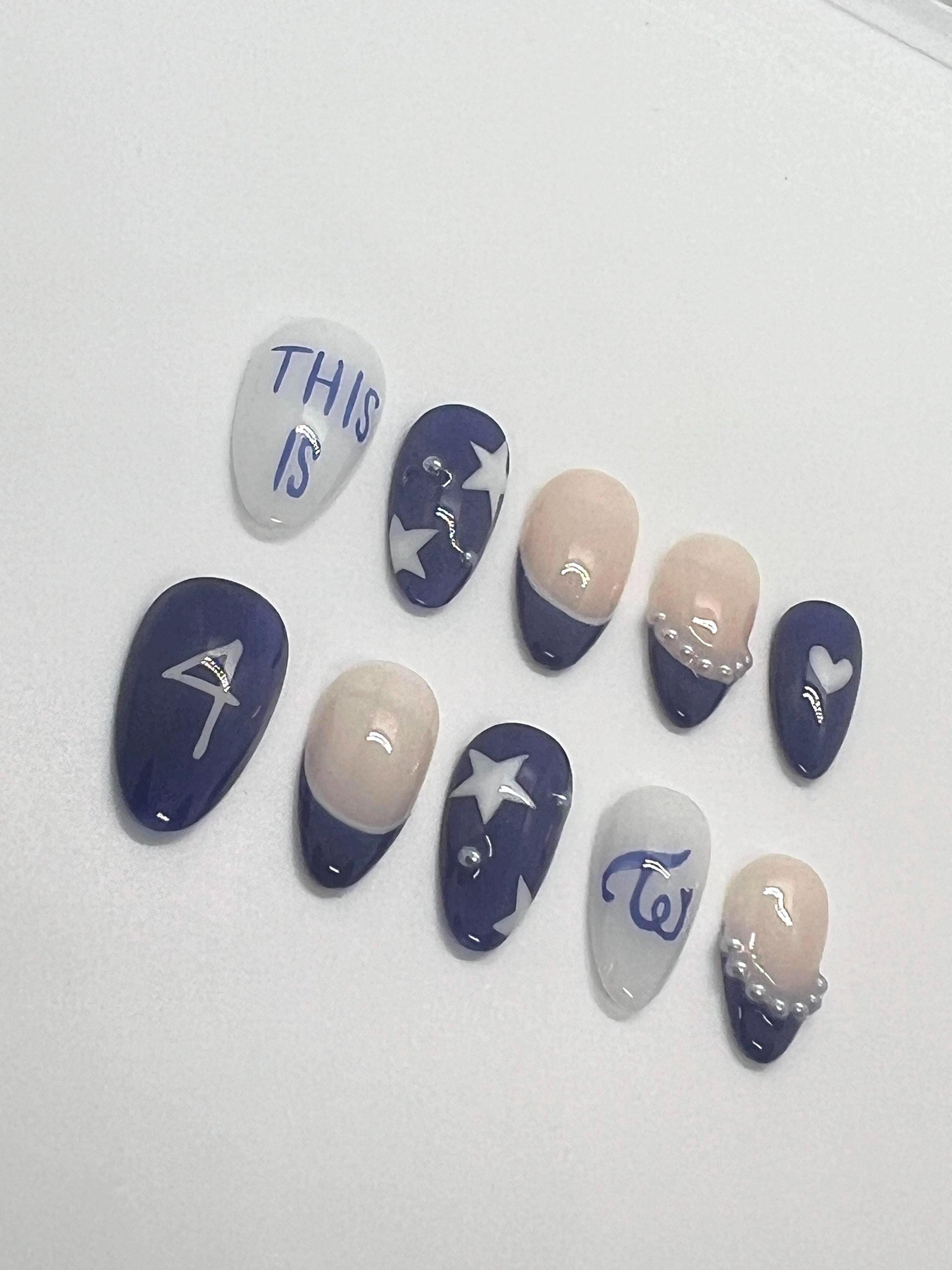 This TWICE-inspired handmade press-on nail set blends soft glam with playful charm, reflecting the group’s signature elegance and confidence. Featuring blue and beige tones with delicate details and polished finishes, these nails capture the essence of TWICE’s iconic stage presence.
